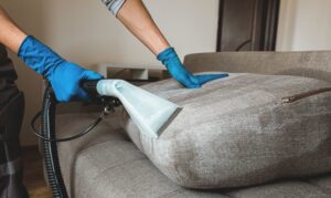 A professional performing upholstery steam cleaning service for Pure Steam Carpet Cleaning in Nashville, TN