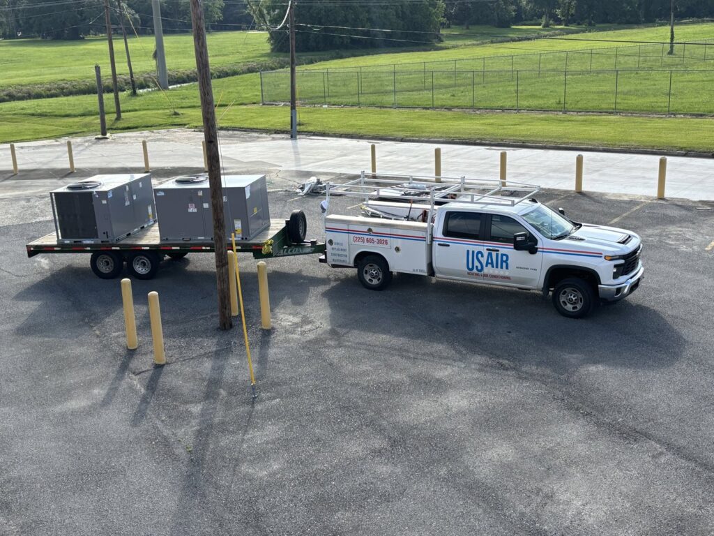 A US AIR service truck with a trailer transporting new HVAC units for installation in Baton Rouge, LA.
