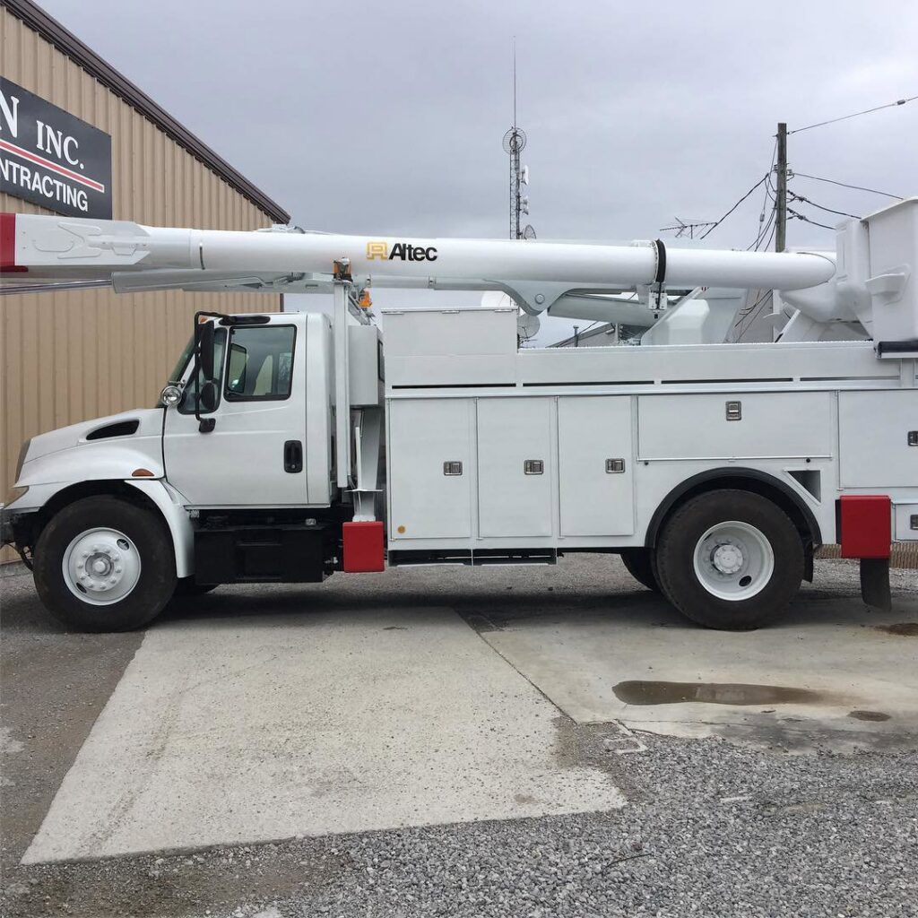 A white utility bucket truck, commonly used for electrical line work, parked outside for Babcon Electric Inc. in Richmond, KY