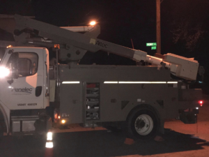 A utility bucket truck with its arm extended, performing electrical work at night for DRS Electric Co. in Erie, PA.
