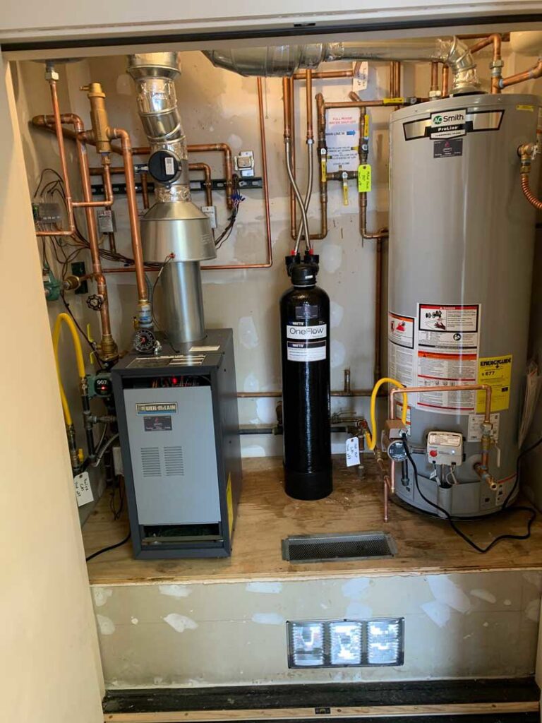 A utility closet showcasing a complex HVAC and plumbing system installation by Jerome's Mechanical, LLC in Santa Fe, NM