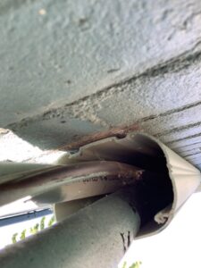 A utility pipe entering a building, showing potential gaps for pest entry or recent exclusion work by Moderno Pest Control in Fort Wayne, IN.