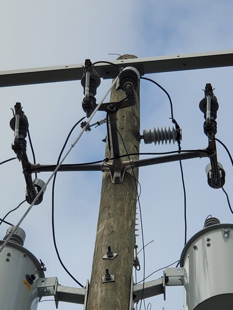 A utility pole with transformers and complex wiring, representing work by Dobson Electric, Inc. in Jacksonville, FL.