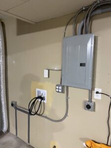An electrical panel, outlets, and conduit in a utility room installed by Good Contact Electric, LLC in Tacoma, WA.