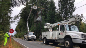 Utility workers repairing power lines and transformers from a boom lift for Universal Electric & Solar PNW in Port Orchard, WA