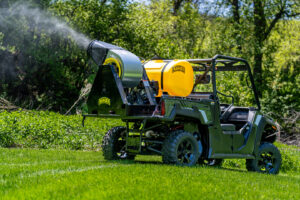 A utility vehicle performing mosquito spraying services in a green outdoor area for Fog'em Mosquito Control in Bismarck, ND.