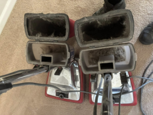 Two professional vacuum cleaner dustbins full of collected dirt after a carpet cleaning job by Steamex Carpet Cleaning Phoenix, AZ.