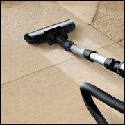 A vacuum cleaner head making clean lines on a carpet, demonstrating carpet cleaning by Sunrise Cleaning Services in Saint Petersburg, FL.