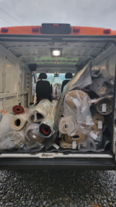 A delivery van filled with numerous rolled-up carpets and rugs for Advanced Cleaning Systems in Atlanta, GA.