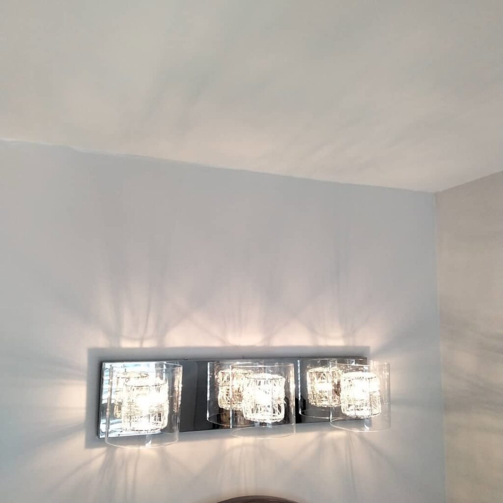 A stylish vanity light fixture with three glass shades installed by J3 Services in Goose Creek, SC.