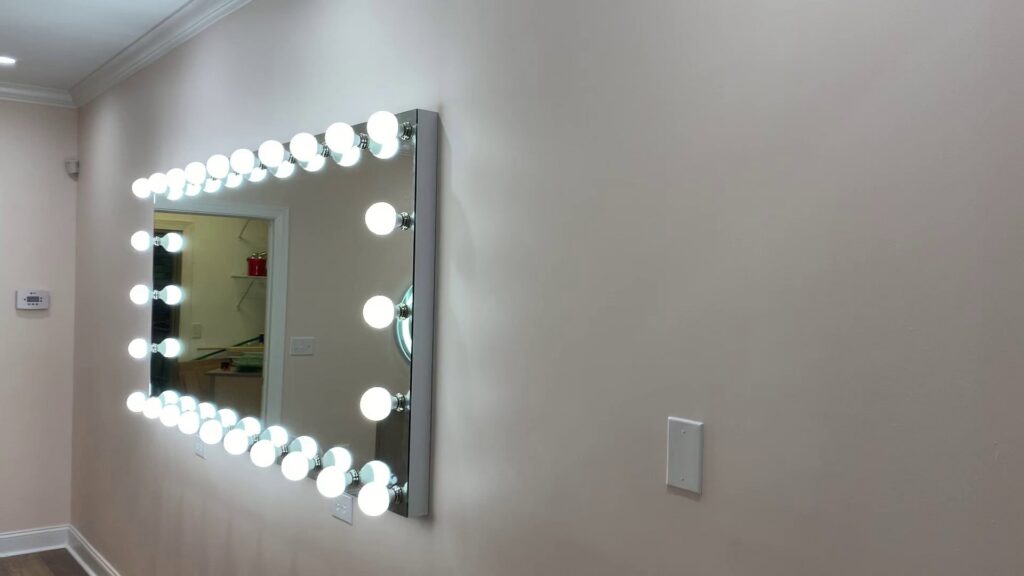 A large vanity mirror with multiple exposed light bulbs, expertly installed by Harbour Electric in Wilmington, NC.