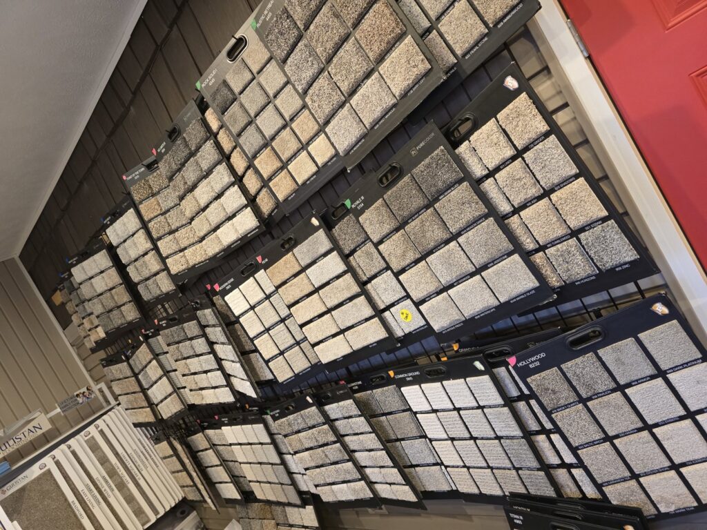A wide variety of carpet samples displayed on a wall in the Big Red Flooring showroom in Omaha, NE