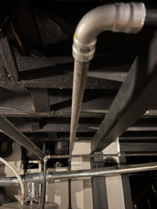 A network of utility pipes, including gas and water lines, in a basement or utility area, serviced by Basurto's Heating & Cooling in Milwaukee, WI.