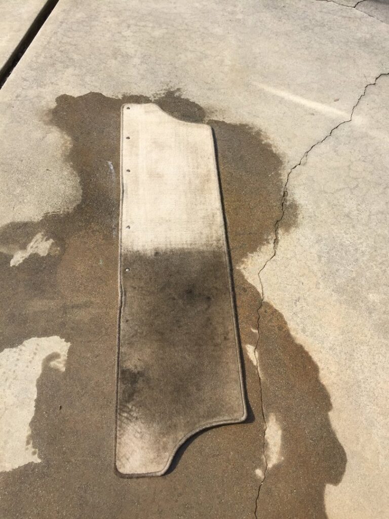 A vehicle floor mat showing a clear before and after cleaning by JS Carpet Cleaning in San Jose, CA