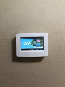 A Venstar smart thermostat installed on a wall, representing HVAC control systems by Peace & Comfort Heating and Air in San Diego, CA.