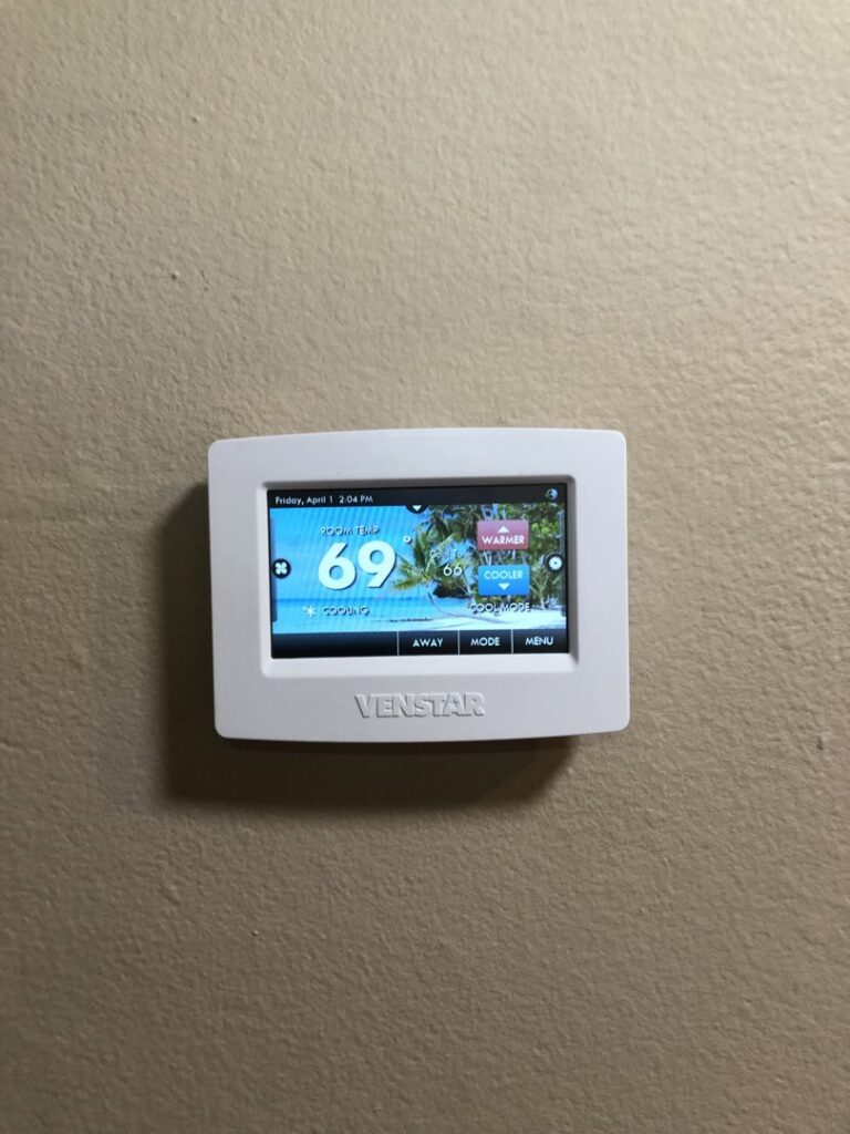 A Venstar smart thermostat installed on a wall, representing HVAC control systems by Peace & Comfort Heating and Air in San Diego, CA.