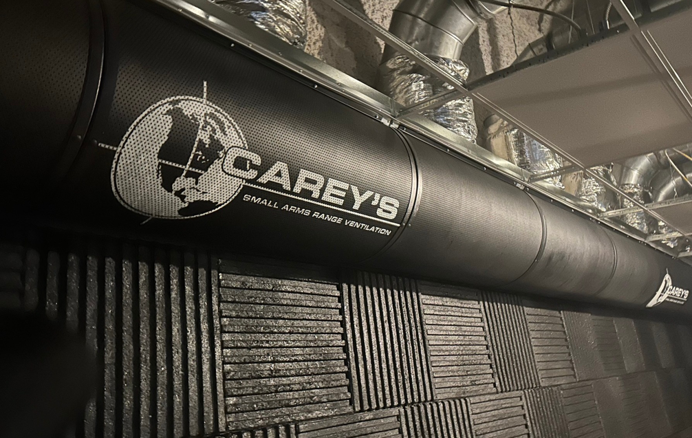 A large black ventilation duct with the Carey's Small Arms Range Ventilation logo installed in a shooting range in Tinley Park, IL.