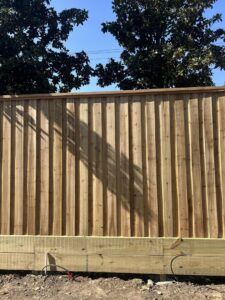 A newly installed vertical wood fence with a sturdy baseboard by Wood Fence Houston in Houston, TX.