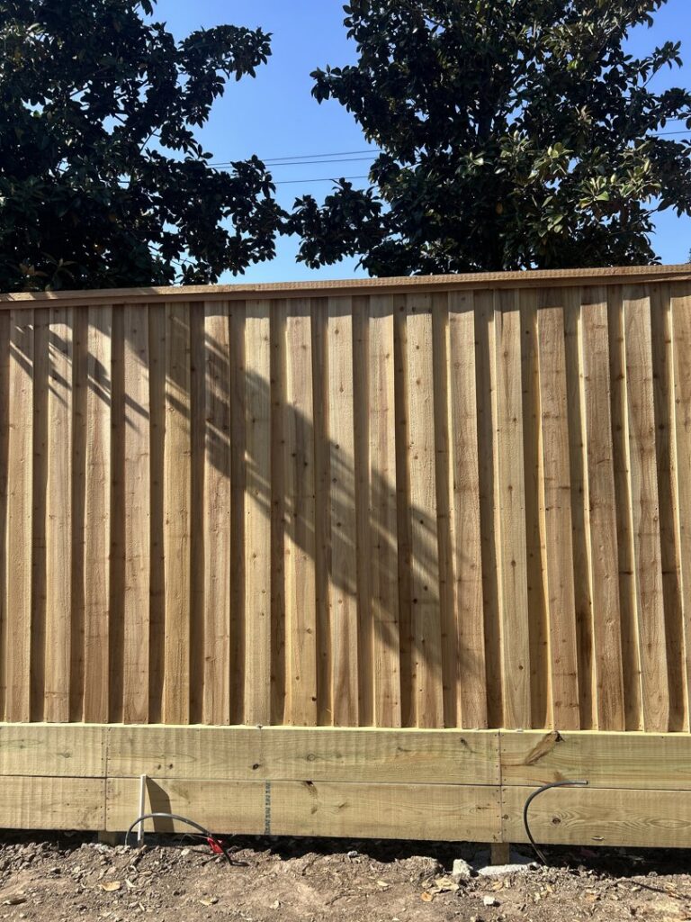 A newly installed vertical wood fence with a sturdy baseboard by Wood Fence Houston in Houston, TX.
