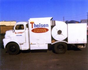 A vintage furnace cleaning truck with 'Theisen Furnace Cleaning' logo, used by Theisen Heating, Air Conditioning & Furnace Cleaning in Yakima, WA.