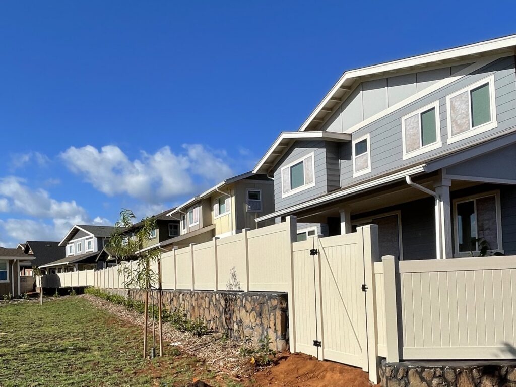 A long vinyl fence installation with a gate around a residential development by 702 Fence LLC in Las Vegas, NV.