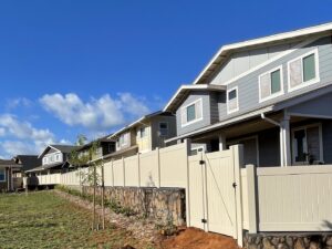 A long vinyl fence installation with a gate around a residential development by 702 Fence LLC in Las Vegas, NV.