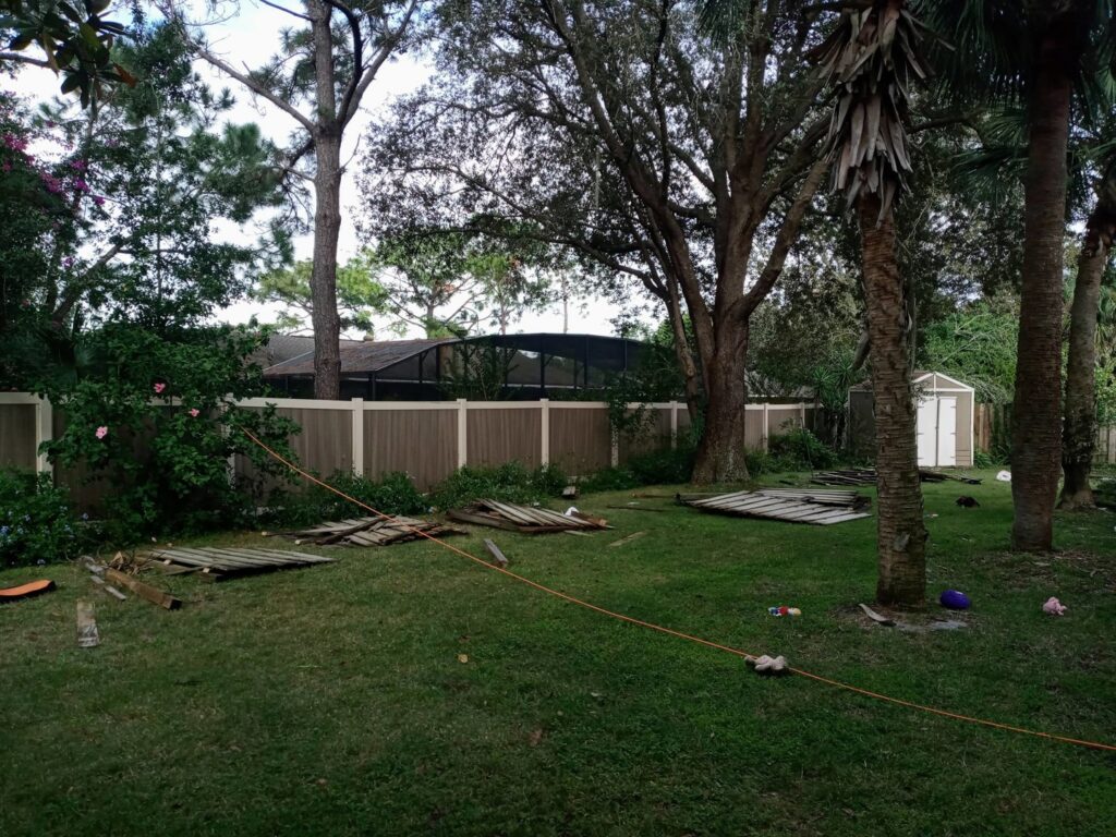A vinyl fence replacement project in progress with new panels installed and old panels on the ground by Florida Professional Fence LLC in Altamonte Springs, FL.