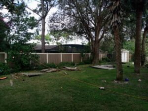 A vinyl fence replacement project in progress with new panels installed and old panels on the ground by Florida Professional Fence LLC in Altamonte Springs, FL.