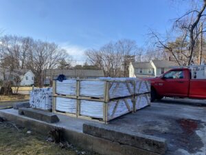 Pallets of vinyl fencing materials next to a work truck for Texeira Fencing & Concrete in Springfield, MA.