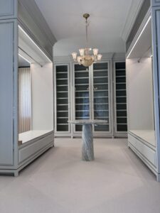 A luxurious walk-in closet featuring a chandelier and integrated shelf lighting, installed by Johnson Electric in Port Angeles, WA.