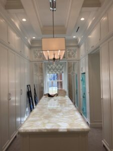 A spacious walk-in closet with recessed lighting and a stylish central fixture, installed by Johnson Electric in Port Angeles, WA.