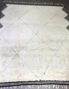 A vibrant wall display of various patterned rugs and carpets in the Organic Looms showroom in Scottsdale, AZ