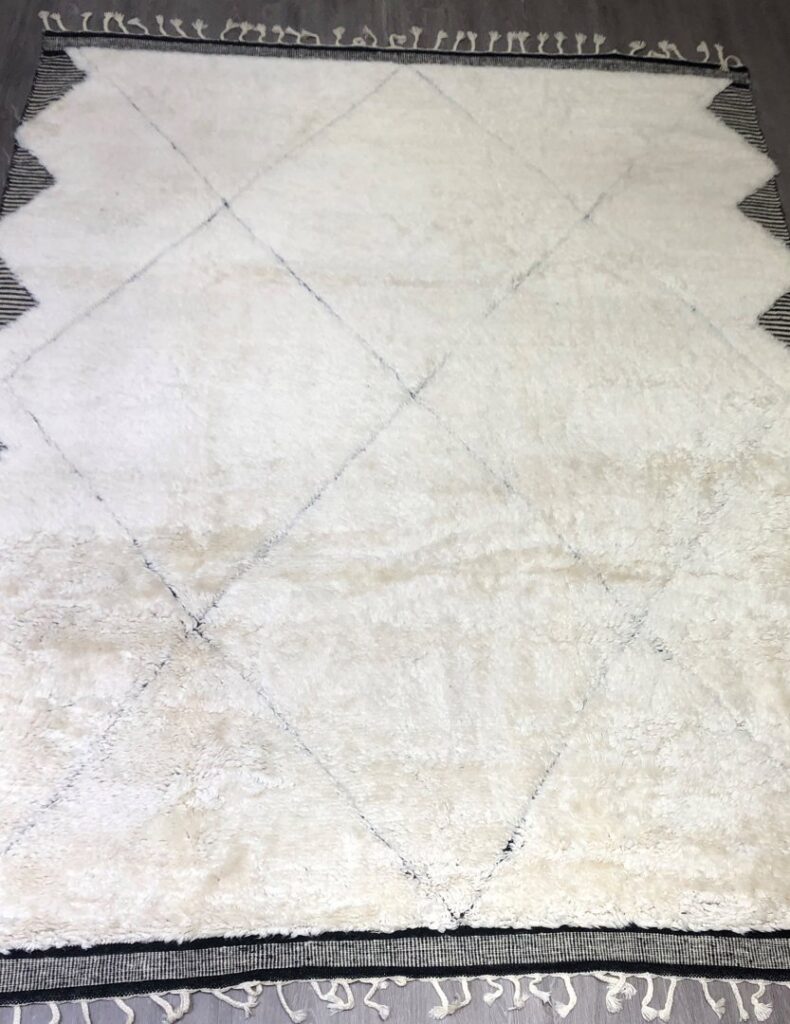 A vibrant wall display of various patterned rugs and carpets in the Organic Looms showroom in Scottsdale, AZ