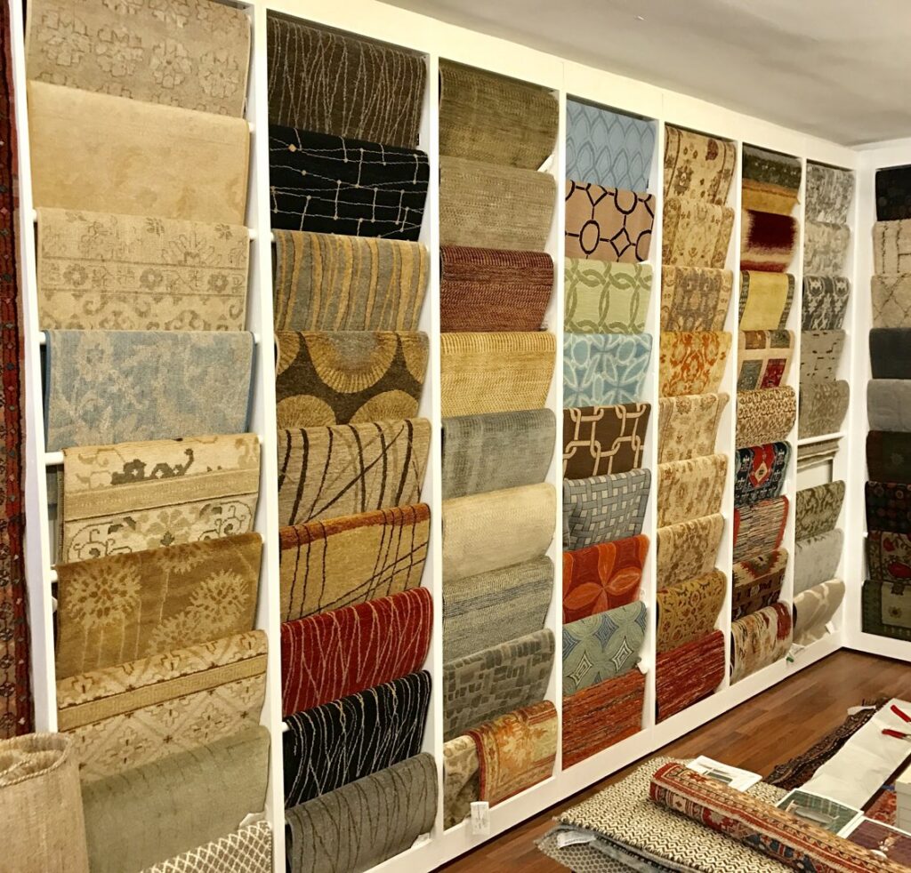 A wall display showcasing various rug samples and patterns at Robert Fritz Oriental Rugs, Inc. in Raleigh, NC