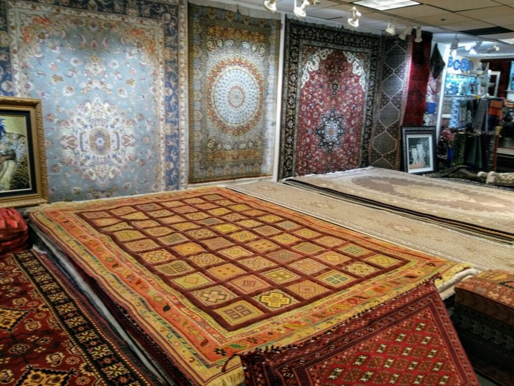 Beautiful Persian rugs displayed on walls and floors in the Art Of Persia store in Portland, OR.
