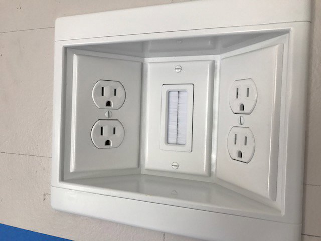 Newly installed wall-mounted electrical outlets and a cable pass-through plate by Jeremy Electrical in Roeland Park, KS.