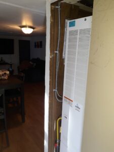 A wall-mounted furnace or heater unit being installed by ABC Mechanical Inc in Lawrenceville, GA.