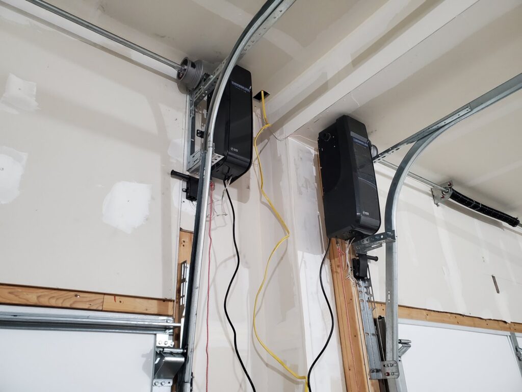Two wall-mounted garage door openers and tracks, installed or serviced by Black Forest Door Repair in Colorado Springs, CO.