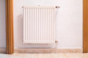 A white wall-mounted heating radiator, representing heating solutions from Infinity Heating & Cooling by Rivera in Kenosha, WI.