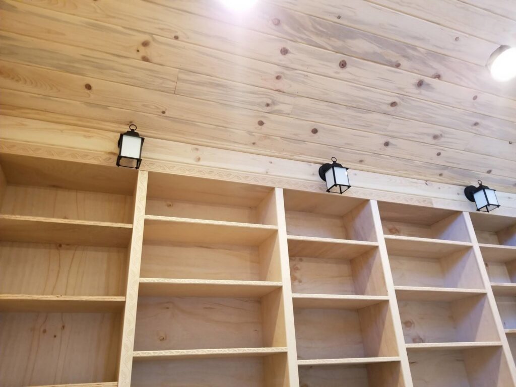 Wall-mounted lantern lights installed above wooden shelves by Grason Electric in Fort Collins, CO.