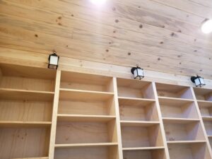 Wall-mounted lantern lights installed above wooden shelves by Grason Electric in Fort Collins, CO.