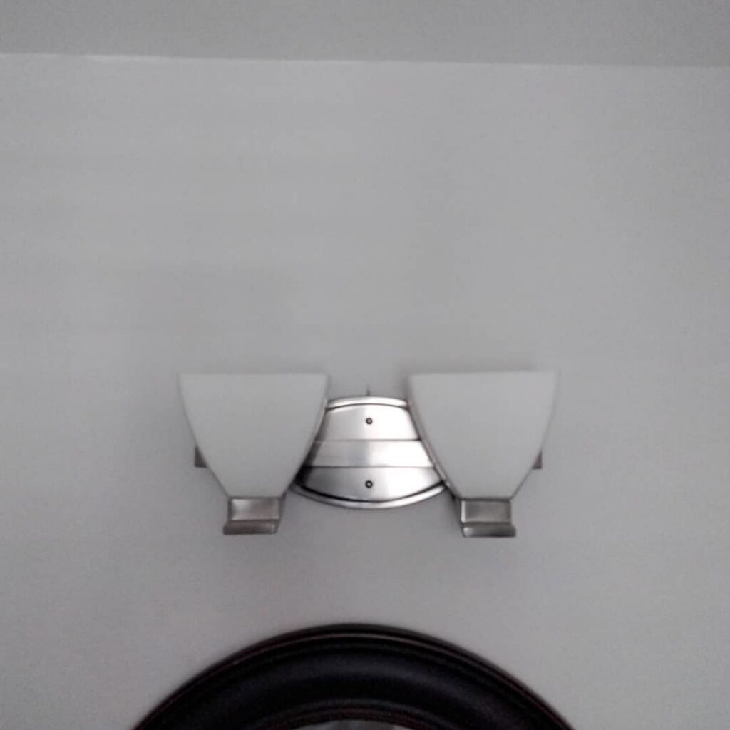 A wall-mounted light fixture with two frosted glass shades installed by J3 Services in Goose Creek, SC.