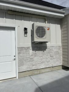 A wall-mounted Mitsubishi Electric mini-split outdoor unit installed by Any Climate Mechanical HVAC in Sandy, UT.