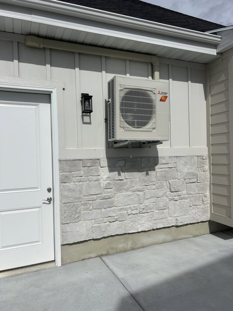 A wall-mounted Mitsubishi Electric mini-split outdoor unit installed by Any Climate Mechanical HVAC in Sandy, UT.