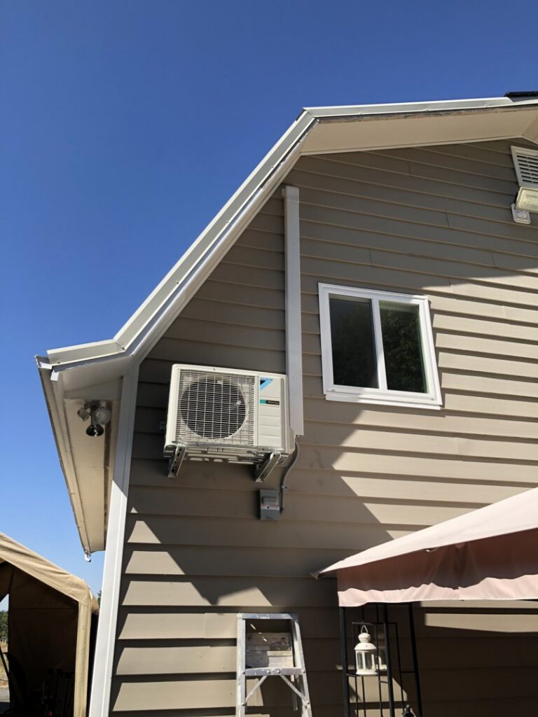 A wall-mounted outdoor mini-split unit installed on a house by DiMartino's 5 Star Heating & Air Conditioning LLC in Salem, OR.
