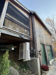 A wall-mounted Samsung heat pump unit installed on the exterior of a building by Rockys electric in La Junta, CO.