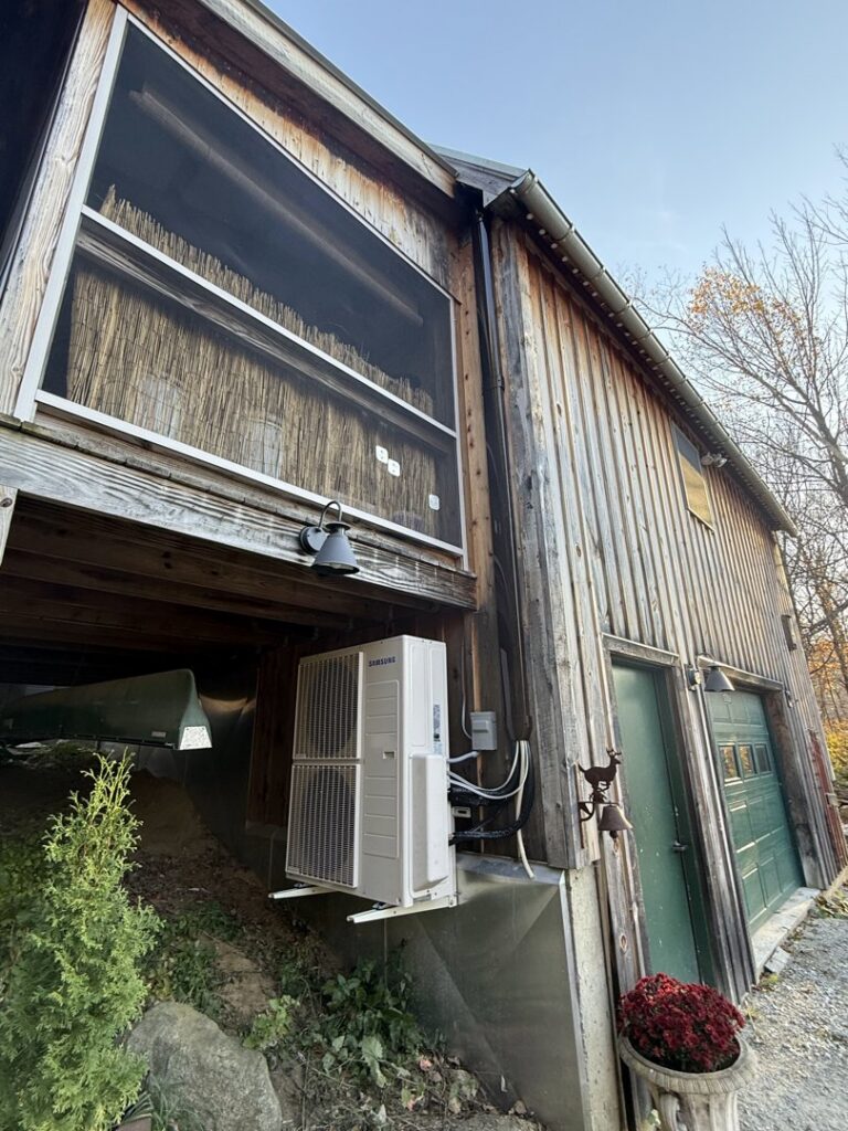A wall-mounted Samsung heat pump unit installed on the exterior of a building by Rockys electric in La Junta, CO.