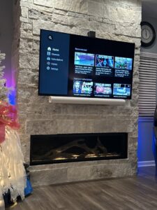 Professional installation of a wall-mounted TV and electric fireplace by Swick Electric in Kansas City, KS.