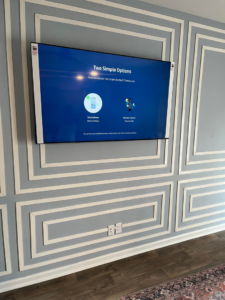 A newly installed wall-mounted TV with electrical outlets below it, completed by Miller Electric in Summerville, SC.