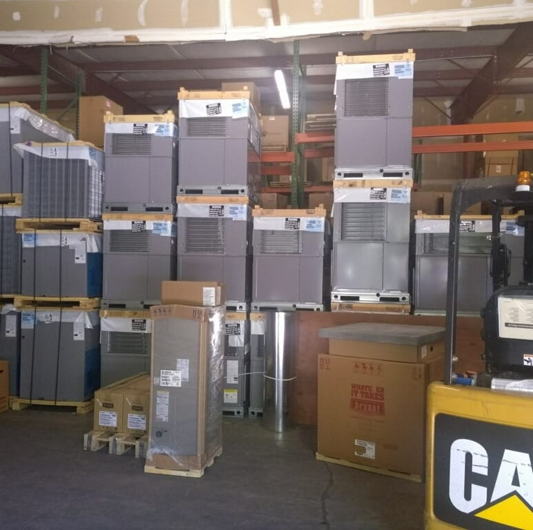 A warehouse filled with stacked HVAC units and equipment, ready for installation by NAS Heating & Air in Fayetteville, NC.